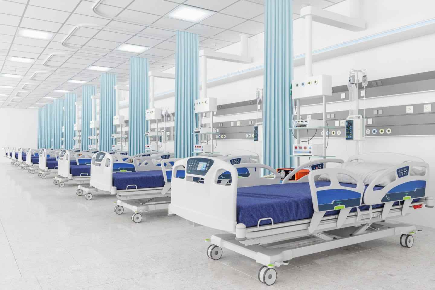 Hospital ward with empty beds, blue curtains, and medical equipment