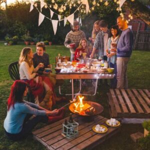 Family enjoying outdoor picnic by table & firepit by Rose Pest Solutions