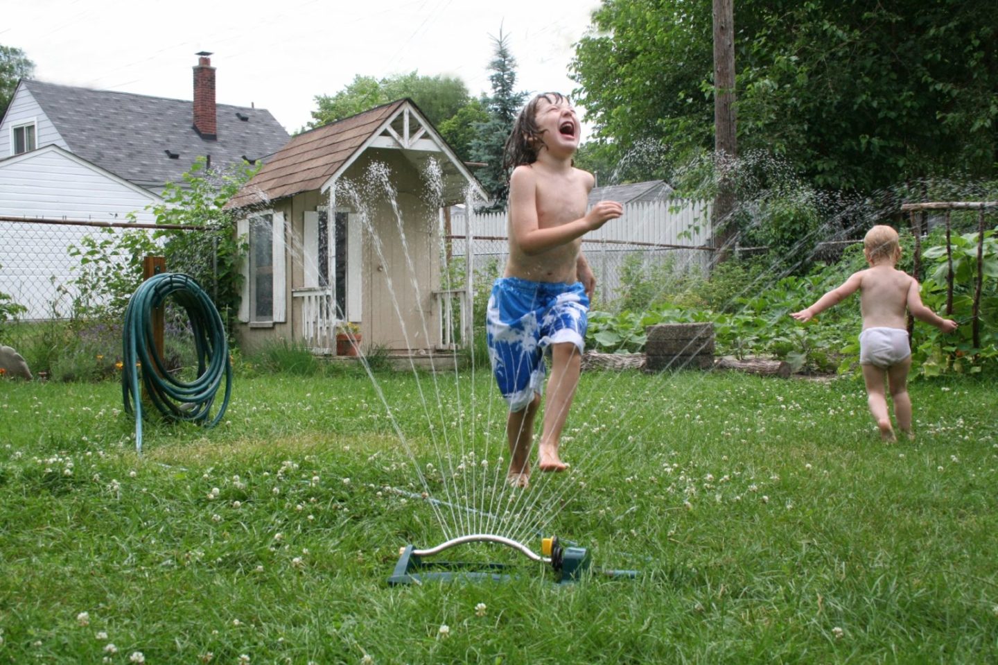 kids_playing_in_sprinkler_outside.jpg