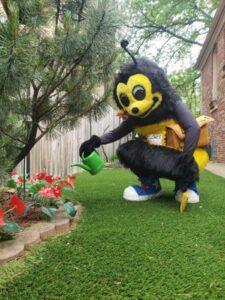 Rose Pest Solutions mascot Zippy watering flowers